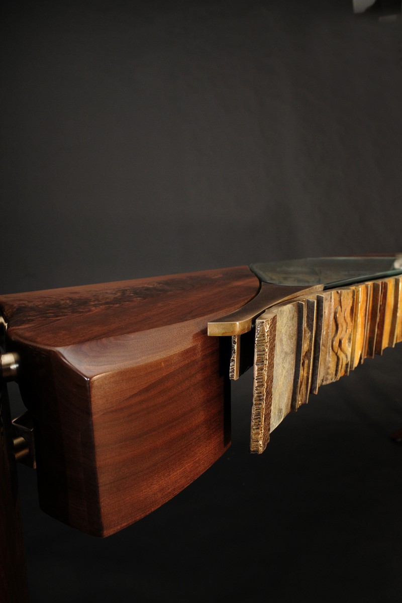 The corner of the table, showing the wood and bronze close together